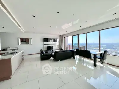 Spacious modern living room with panoramic city views and sleek open kitchen.