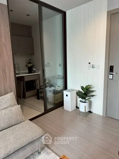 Modern apartment interior with sleek kitchen and cozy living area, featuring stylish decor and smart home technology.