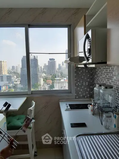 Modern kitchen with city view, featuring sleek appliances and stylish backsplash.