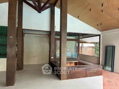 Spacious open-plan living area with high ceilings and wooden accents, perfect for modern living.