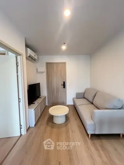 Modern living room with sleek furniture and wooden flooring, perfect for cozy urban living.