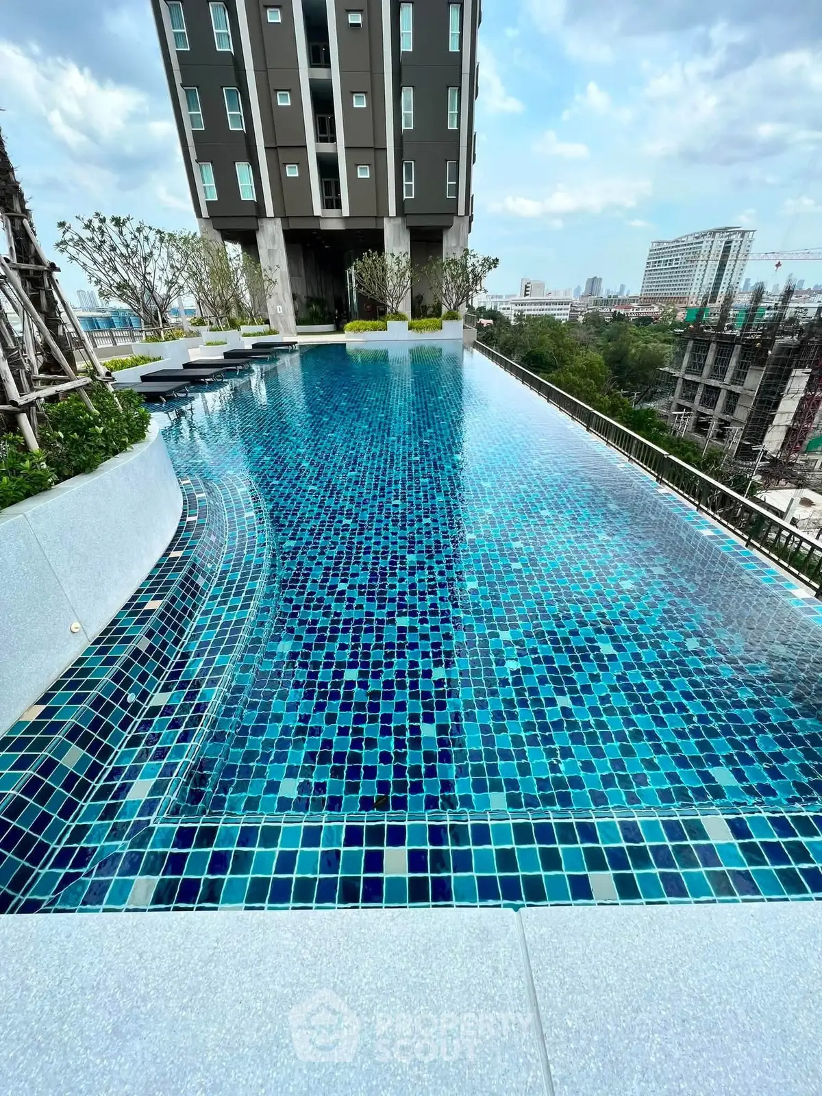 Luxurious rooftop infinity pool with stunning cityscape views in modern high-rise building.