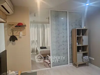 Cozy bedroom with sliding floral glass doors and modern shelving unit.