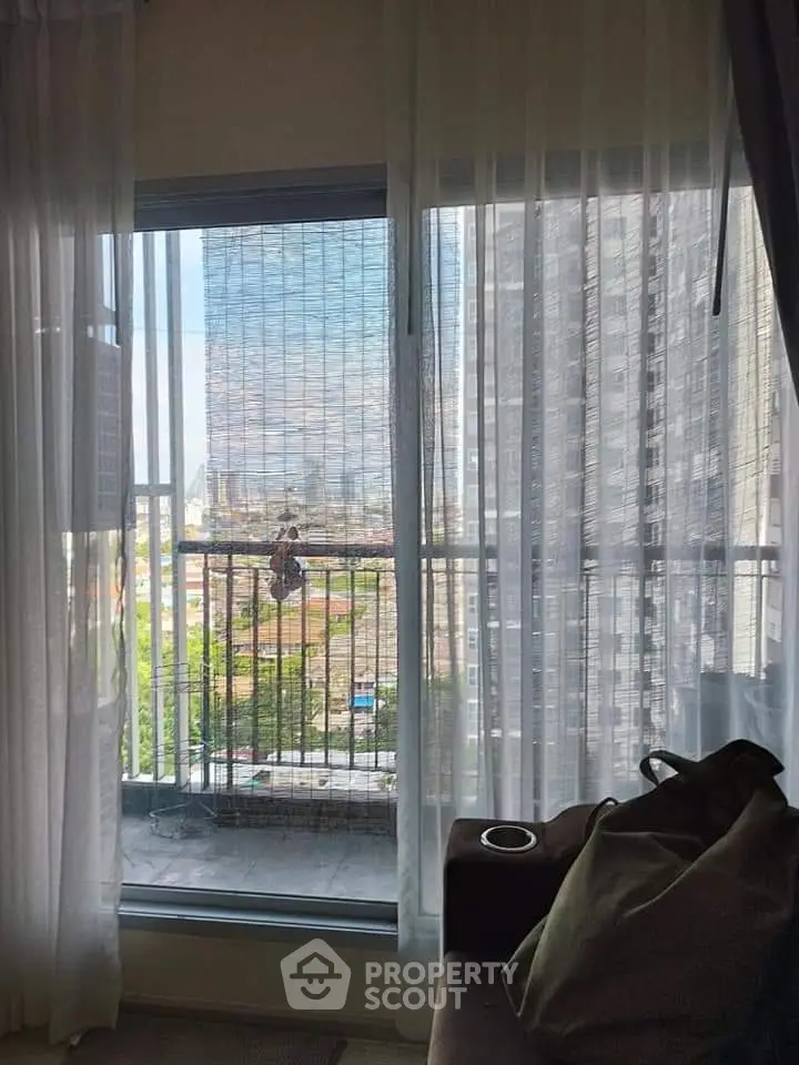 Modern apartment with city view through large window and sheer curtains
