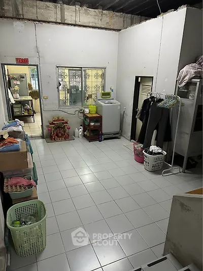 Spacious laundry room with washing machine and ample storage space in a residential property.