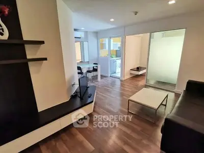 Modern living room with sleek furniture and open layout, featuring hardwood floors and stylish decor.