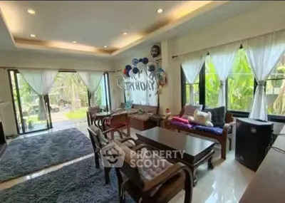 Spacious living room with elegant decor and garden view, perfect for family gatherings.