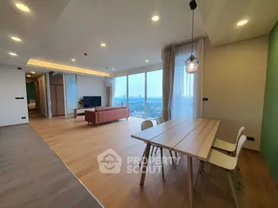 Spacious modern living room with panoramic city view and elegant dining area.