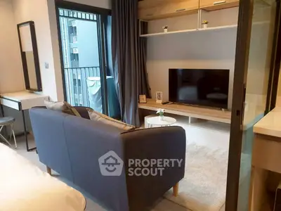 Modern living room with cozy sofa and TV, featuring a small balcony view.