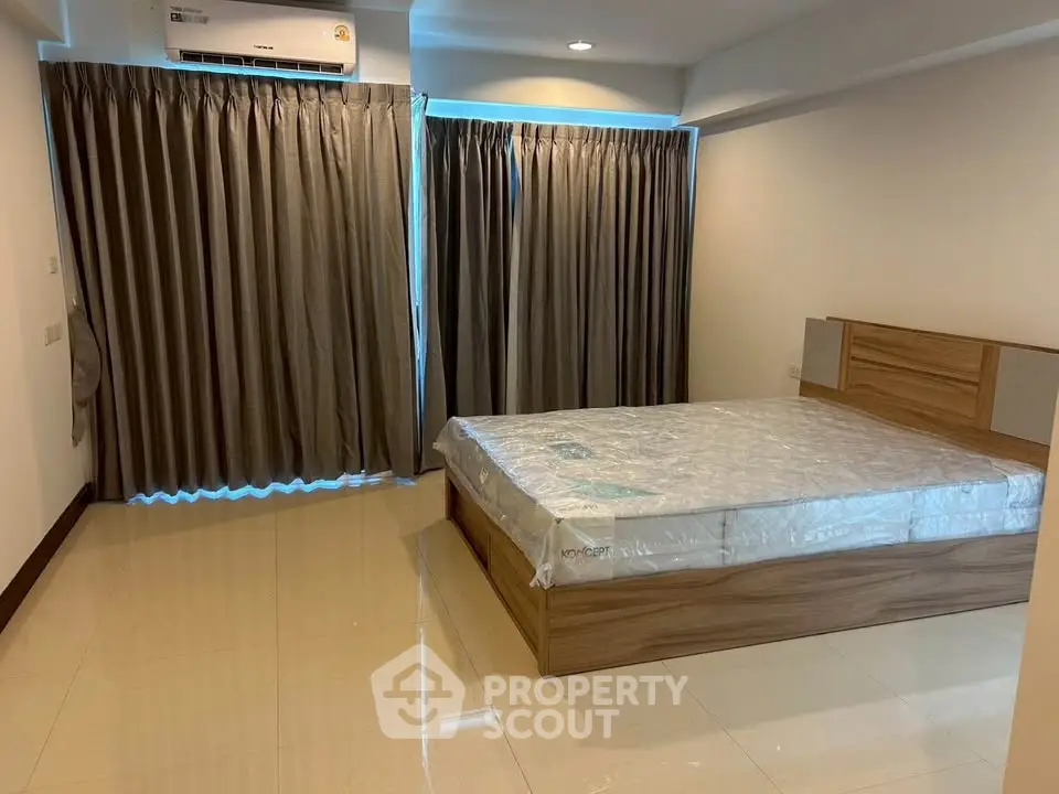 Spacious bedroom with modern design and large windows for natural light.