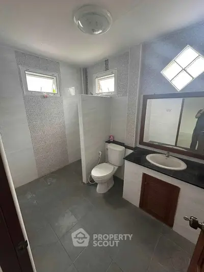 Spacious modern bathroom with sleek tiles and natural light.