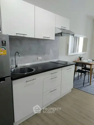 Modern kitchen with sleek cabinetry and dining area in a stylish apartment