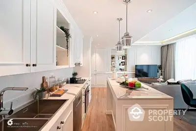 Elegant open-layout kitchen with modern appliances and finishes, leading to a cozy living area with ample natural light.