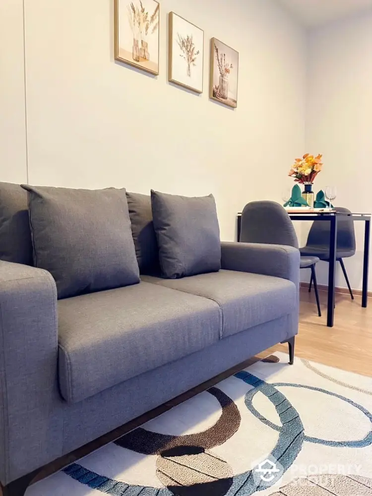 Modern living room with stylish gray sofa and elegant dining area