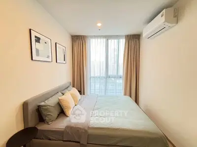 Modern bedroom with stylish decor and large window offering city view.