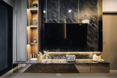 Luxurious living room with marble wall feature and mounted flat-screen TV, complemented by elegant shelving and chic decor.