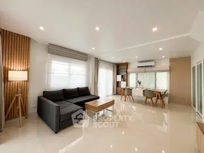 Spacious modern living room with sleek furniture and dining area, perfect for family gatherings.