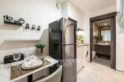 Modern kitchen with sleek appliances and elegant dining setup in a compact space.