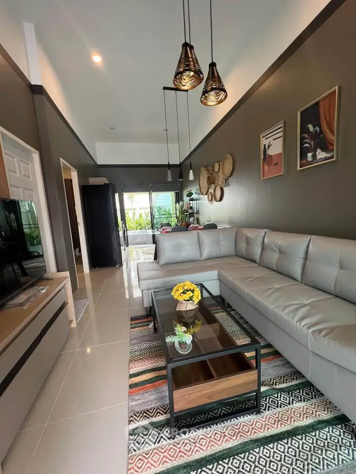 Modern living room with stylish decor, large sectional sofa, and pendant lighting, offering a cozy and inviting atmosphere.