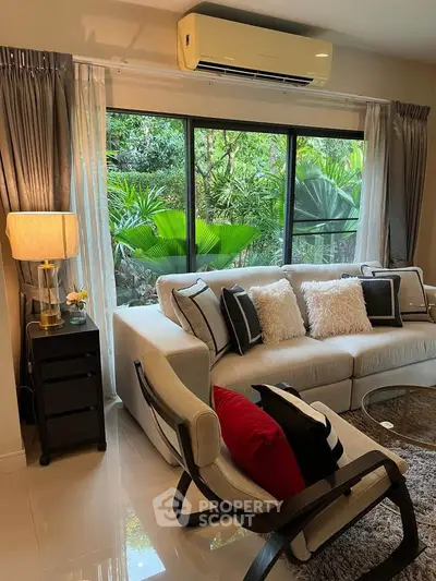 Stylish living room with modern furniture and large window overlooking lush greenery, perfect for relaxation.