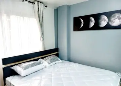 Modern bedroom with moon phase artwork and natural light