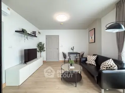 Modern living room with sleek black sofa, stylish decor, and natural light.