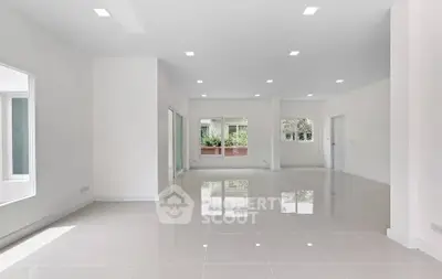 Spacious open-plan living area with glossy tiled floors and large windows.