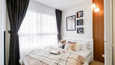 Cozy bedroom with stylish decor and large window for natural light