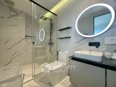 Luxurious modern bathroom with marble walls and LED mirror lighting