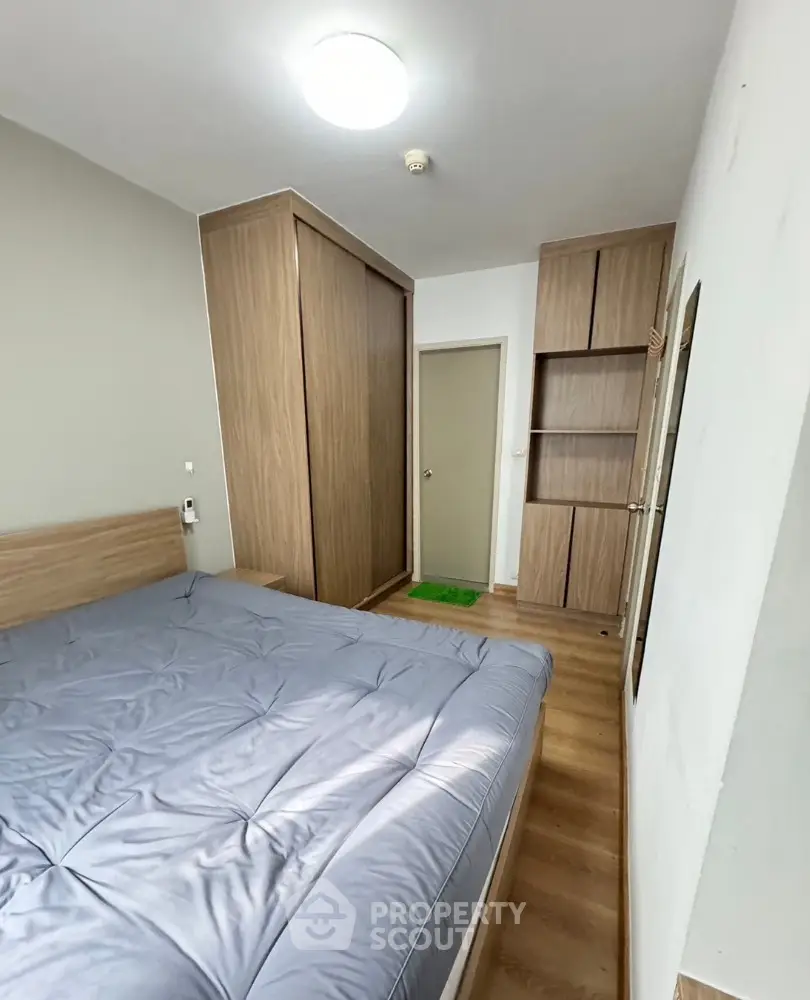 Cozy bedroom with wooden flooring and built-in wardrobe, perfect for modern living.