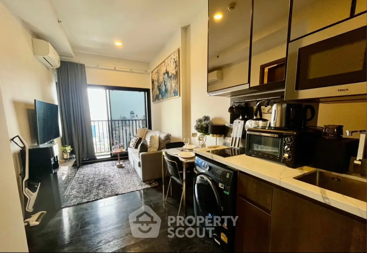 Modern open-layout living room with kitchen, featuring sleek appliances and a cozy seating area with city view.