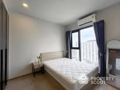 Modern bedroom with large window and city view, featuring a comfortable bed and sleek design.