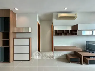 Modern living room with sleek wooden furniture and air conditioning unit, perfect for comfortable living.