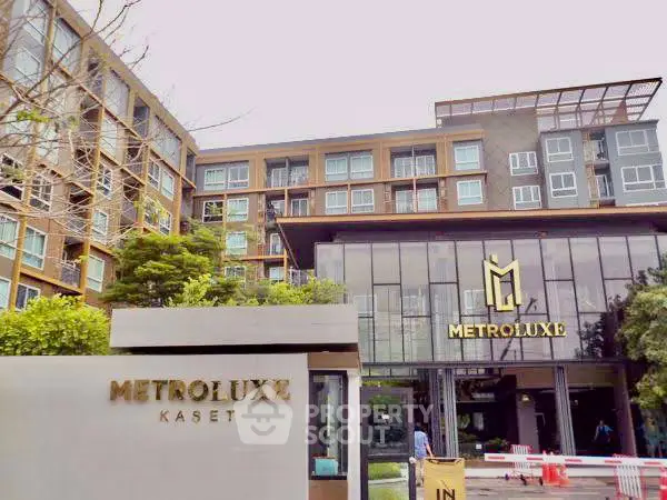 Modern apartment building exterior with Metroluxe Kaset signage and lush greenery.