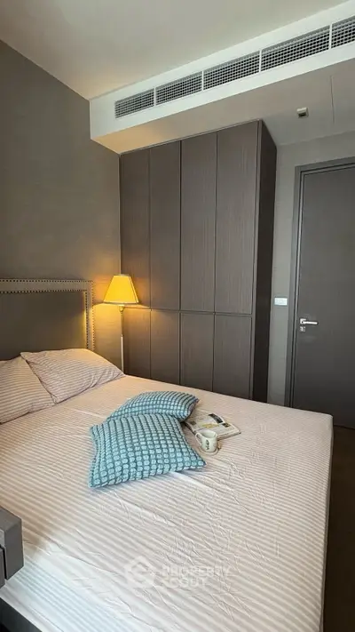 Cozy bedroom with modern decor and ample storage space in a stylish apartment.