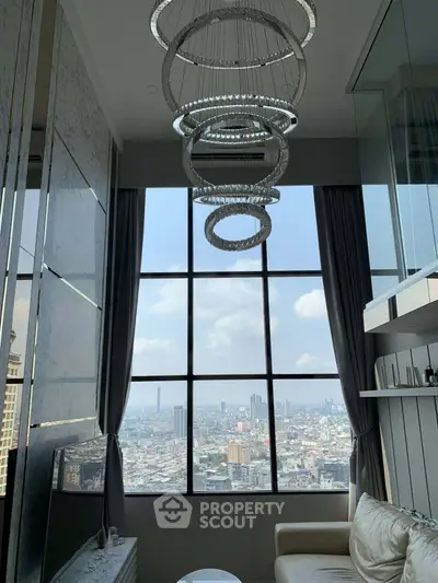 Luxurious high-rise living room with stunning city view and modern chandelier.