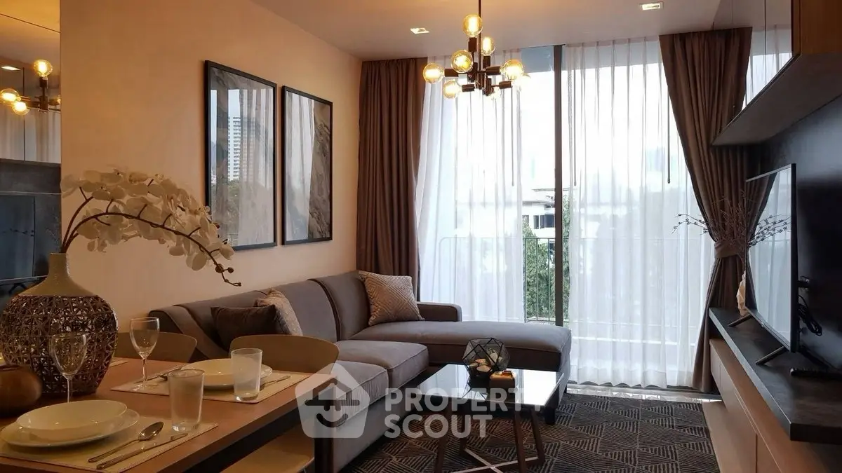 Modern living room with elegant decor and large windows offering natural light.