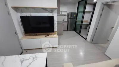 Modern apartment living room with sleek TV setup and open kitchen layout