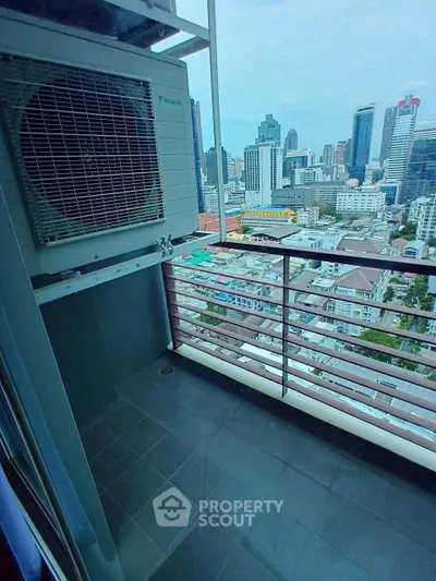 High-rise balcony with city skyline view and air conditioning unit.