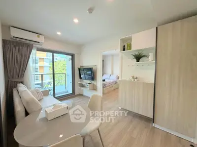 Modern living room with dining area and balcony view in a stylish apartment.
