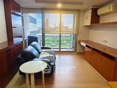 Modern living room with leather sofa, wooden cabinets, and city view balcony.