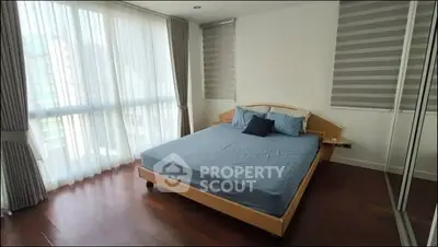 Spacious bedroom with large windows and modern decor