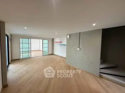 Spacious modern living room with wooden flooring and sliding glass doors