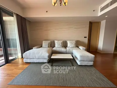 Spacious modern living room with elegant sofa and wooden flooring, perfect for relaxation and entertaining.
