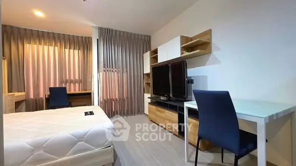 Modern bedroom with study area, featuring sleek furniture and natural light.