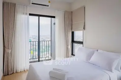 Bright bedroom with city view and balcony access, featuring elegant curtains and modern decor.