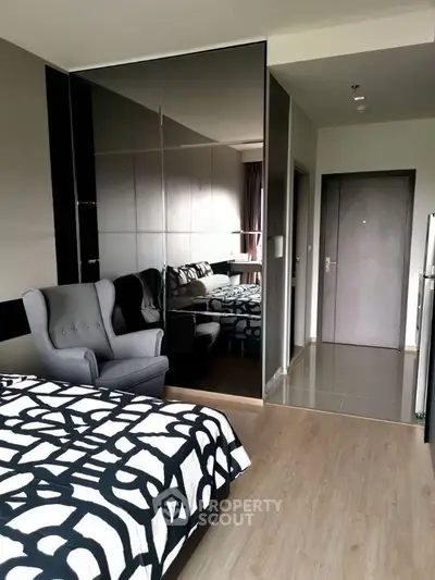 Modern bedroom with stylish decor and mirrored wardrobe in a contemporary apartment.