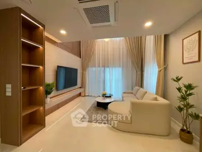 Luxurious modern living room with high ceilings, elegant decor, and natural light.