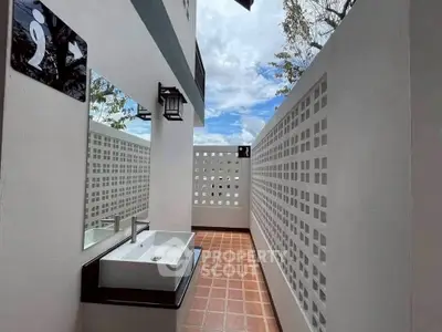 Modern outdoor bathroom with stylish sink and privacy wall