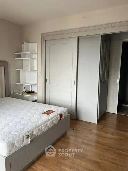 Spacious bedroom with wooden flooring and built-in closet, perfect for modern living.